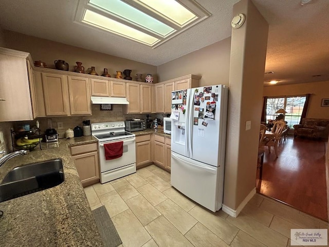 kitchen featuring light brown cabinetry, tasteful backsplash, sink, light stone counters, and white appliances