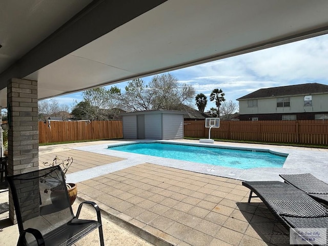 view of swimming pool featuring a storage shed and a patio