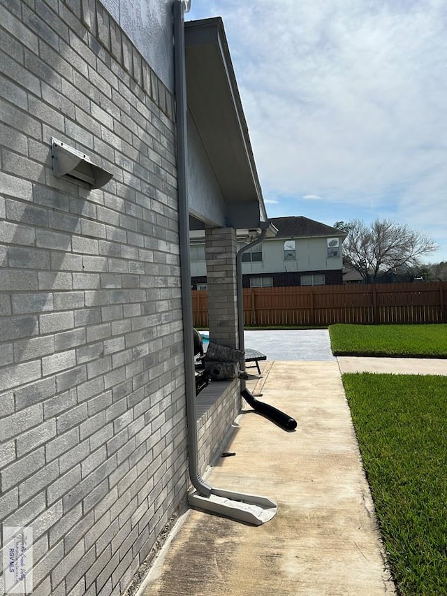 view of side of home with a patio and a lawn