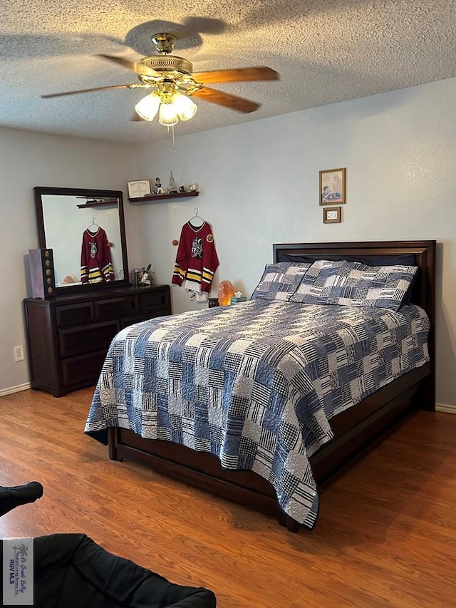 bedroom featuring hardwood / wood-style floors, a textured ceiling, and ceiling fan