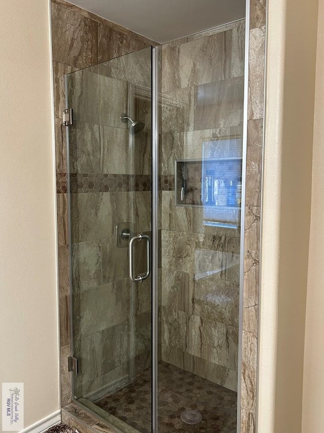 bathroom featuring a shower with door