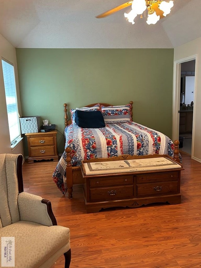 bedroom with wood-type flooring, ceiling fan, and vaulted ceiling