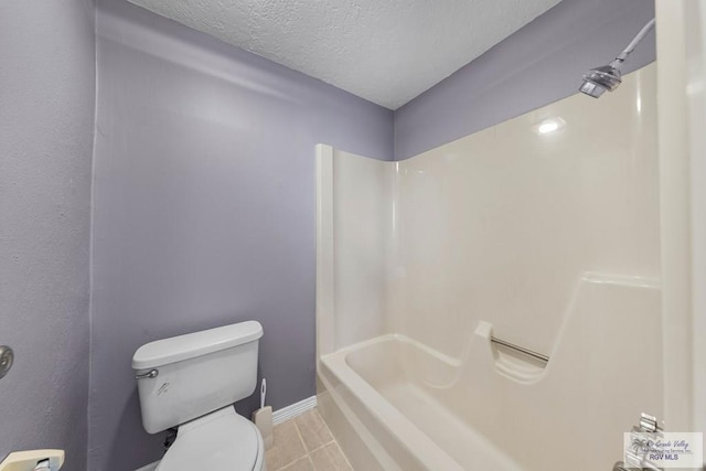 bathroom with toilet, a textured ceiling, tile patterned floors, and bathtub / shower combination