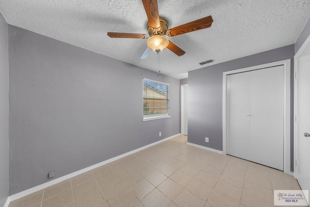 unfurnished bedroom featuring a textured ceiling, ceiling fan, and a closet