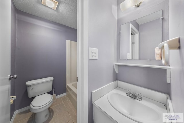 bathroom featuring a textured ceiling, toilet, tile patterned flooring, and vanity