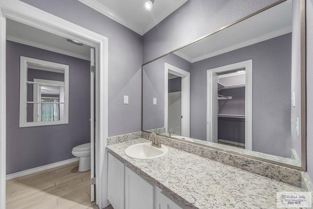 bathroom with hardwood / wood-style floors, toilet, vanity, and crown molding