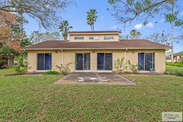 rear view of house featuring a patio area and a lawn