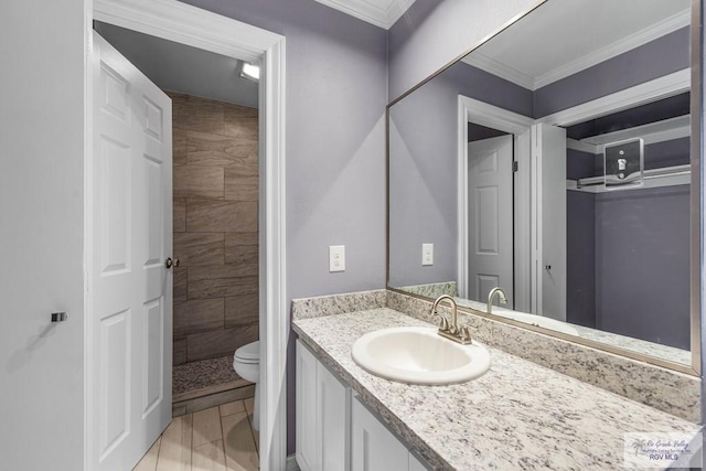 bathroom with toilet, ornamental molding, a tile shower, and vanity