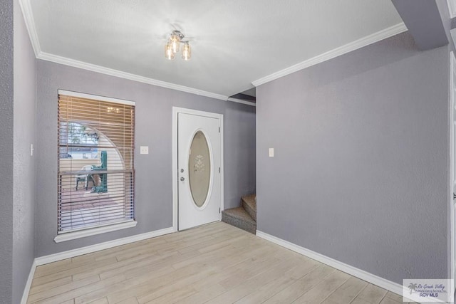 entrance foyer featuring ornamental molding and light hardwood / wood-style flooring