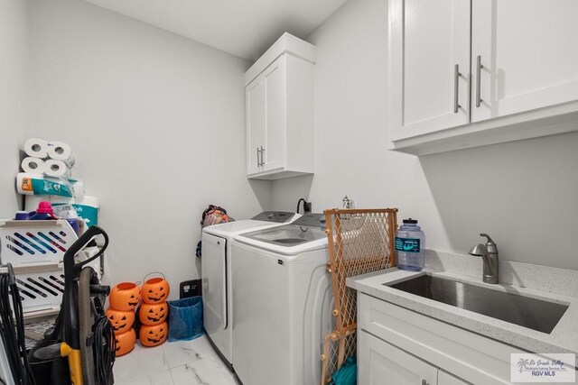 122 Heron Dr, Los Fresnos, TX 78566 - laundry room featuring light marble finish flooring, independent washer and dryer, and cabinet space