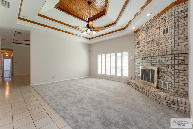 unfurnished living room featuring a fireplace, ceiling fan, a raised ceiling, crown molding, and light carpet