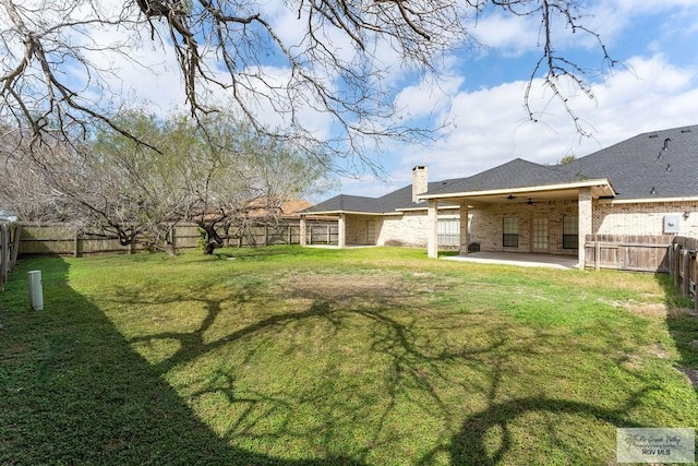 view of yard with ceiling fan and a patio