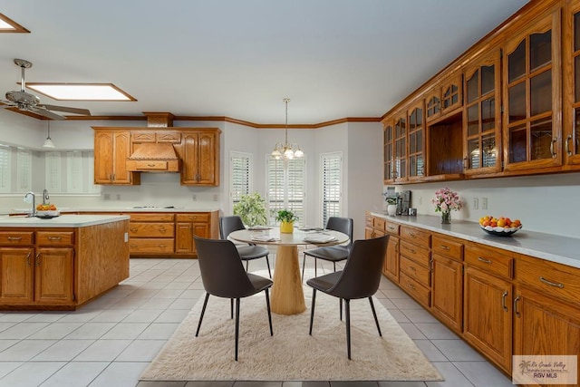 kitchen with light tile patterned floors, a skylight, hanging light fixtures, and a kitchen island