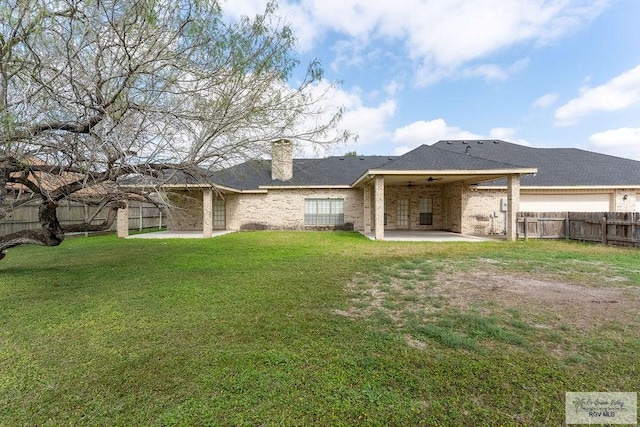 back of property with a lawn and a patio