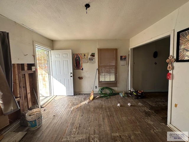 interior space with a textured ceiling and dark hardwood / wood-style floors