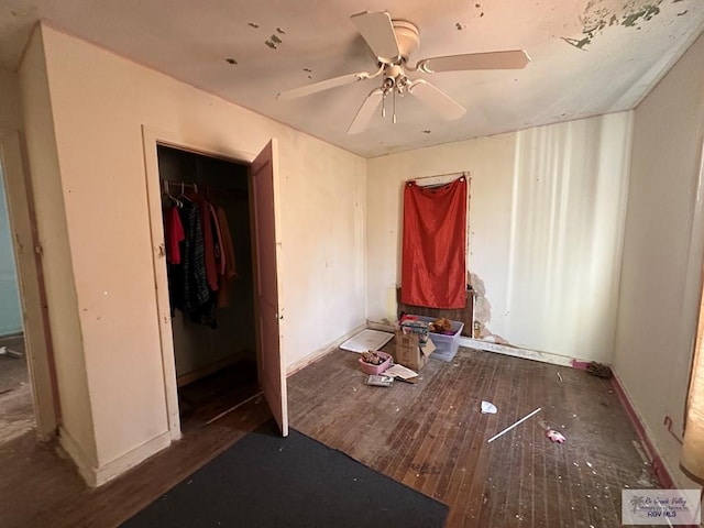 unfurnished bedroom featuring ceiling fan, a closet, and dark wood-type flooring