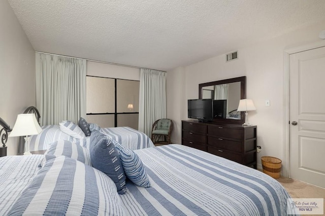 carpeted bedroom featuring a textured ceiling