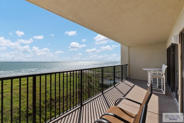 balcony with a water view and a beach view