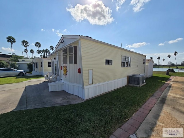 view of home's exterior with cooling unit and a yard