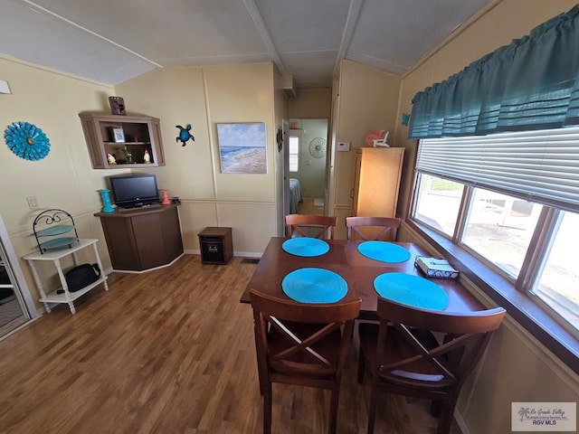 dining room featuring hardwood / wood-style floors and vaulted ceiling