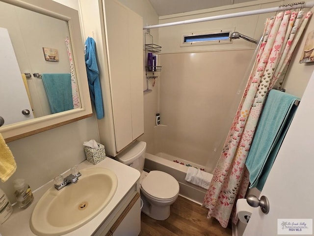 full bathroom featuring hardwood / wood-style flooring, shower / tub combo with curtain, vanity, and toilet