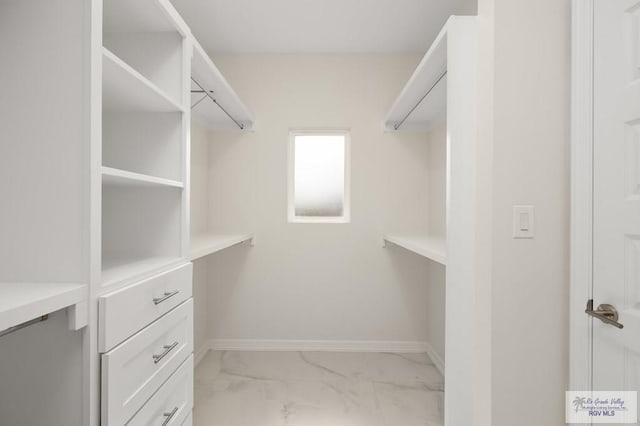 spacious closet featuring marble finish floor