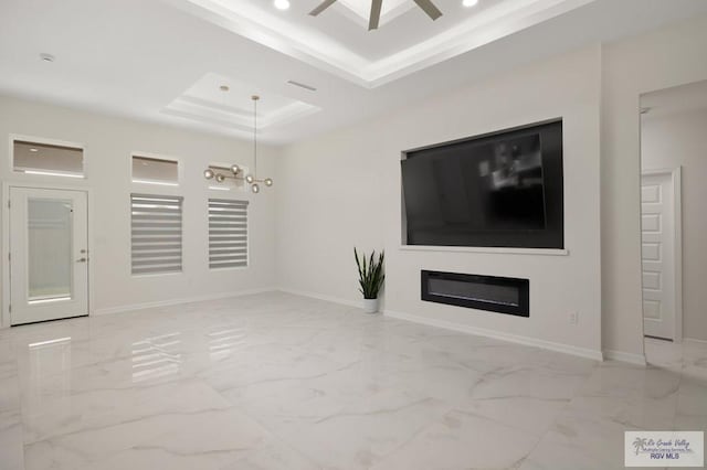 unfurnished living room with a raised ceiling, baseboards, ceiling fan, and marble finish floor