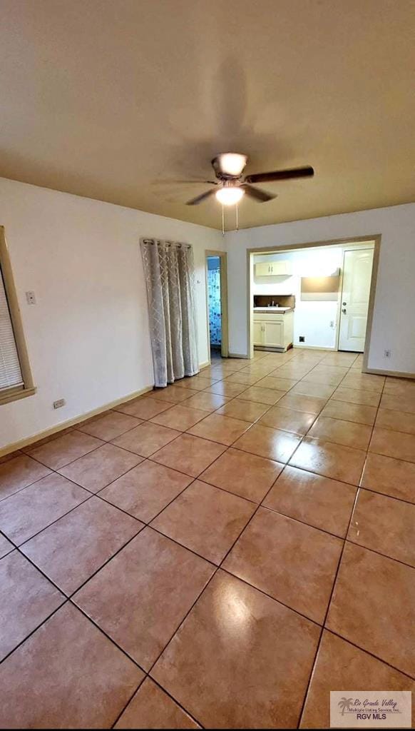 unfurnished room featuring light tile patterned floors, baseboards, and ceiling fan