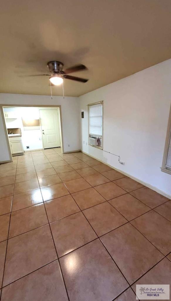 unfurnished room featuring light tile patterned floors, a ceiling fan, and baseboards