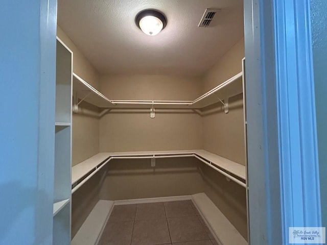 spacious closet with dark tile patterned flooring