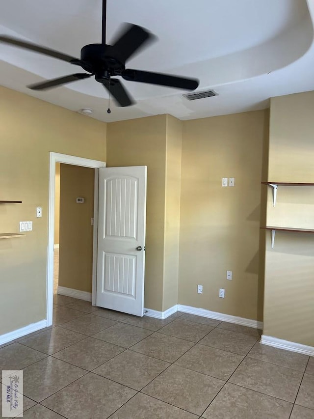 empty room featuring tile patterned floors and ceiling fan