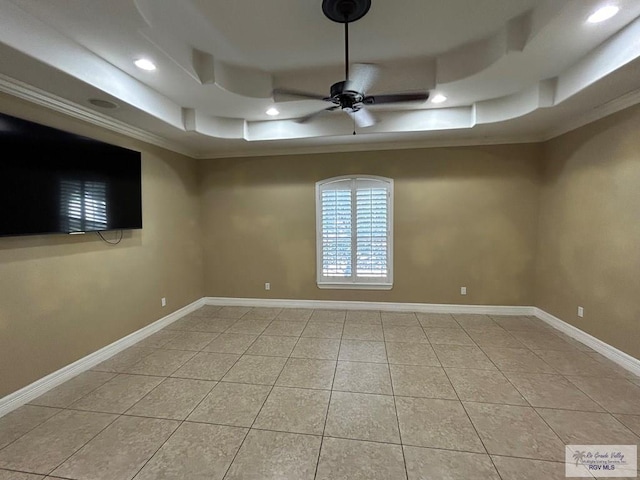 tiled spare room with crown molding, ceiling fan, and a tray ceiling