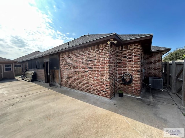 view of side of home featuring central AC unit and a patio area