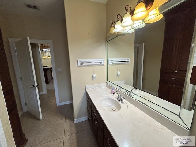 bathroom featuring tile patterned floors, a chandelier, and vanity