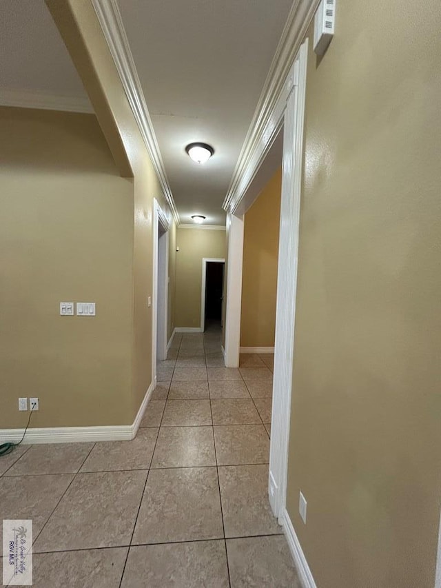 corridor featuring crown molding and light tile patterned floors