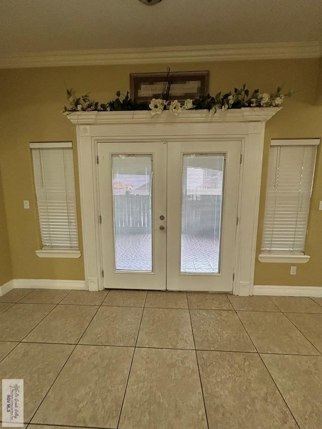 entryway featuring light tile patterned floors, crown molding, and french doors