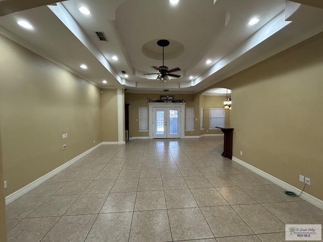 tiled spare room featuring french doors, ceiling fan, and a tray ceiling