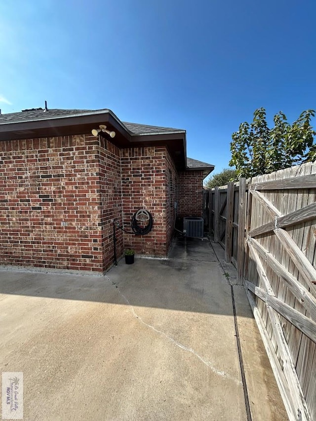 view of side of home with a patio and central AC