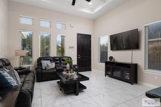 living room with a wealth of natural light, a towering ceiling, and ceiling fan