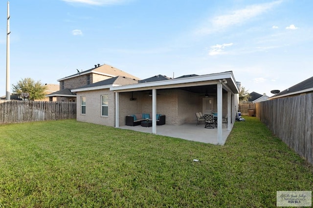 back of house featuring an outdoor living space, a patio area, and a lawn