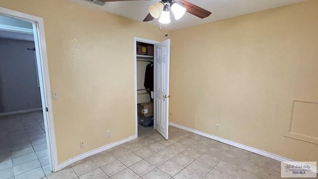 unfurnished bedroom with ceiling fan, a closet, and light tile patterned floors