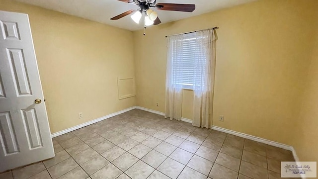 tiled empty room featuring ceiling fan