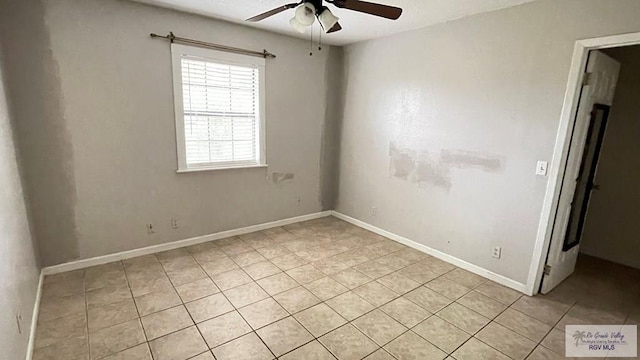 empty room with ceiling fan and light tile patterned floors