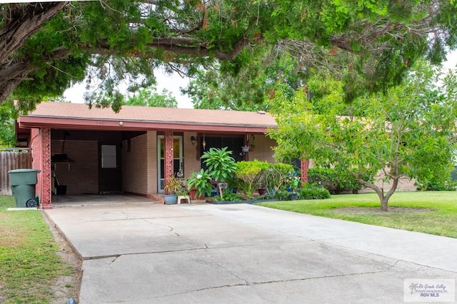 2401 E Austin Ave, Harlingen, TX 78550 - ranch-style home with driveway, a front yard, an attached carport, and brick siding
