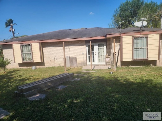 back of property featuring a yard and french doors