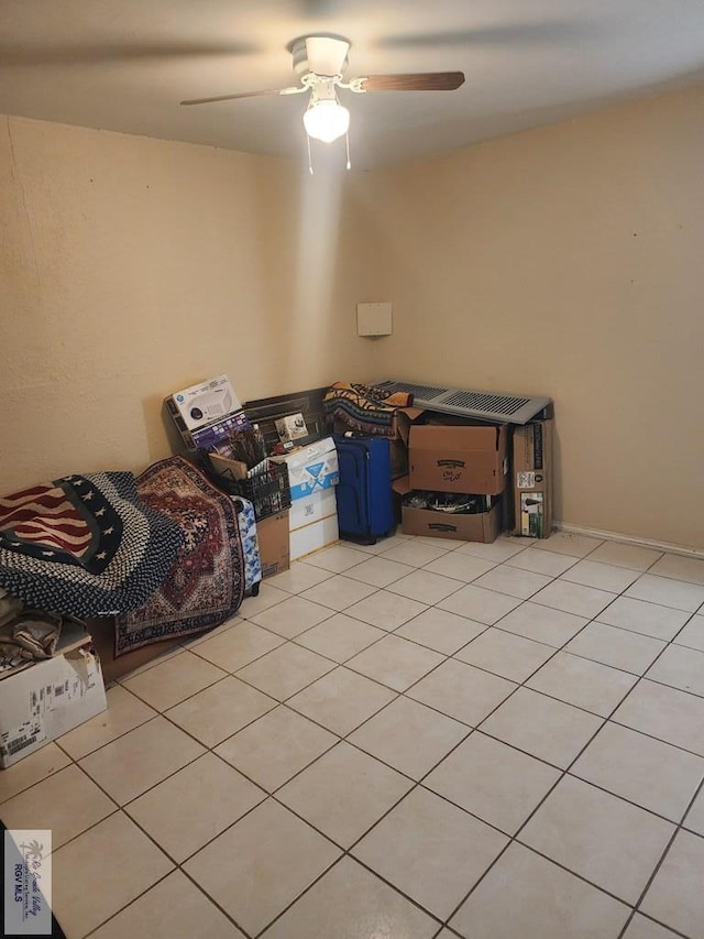 interior space with light tile patterned floors and ceiling fan