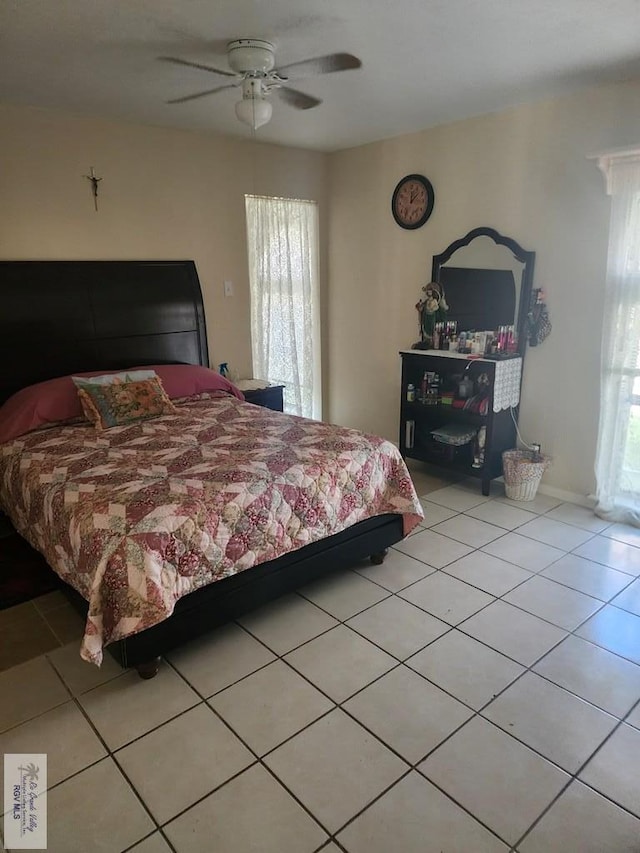 bedroom featuring multiple windows, light tile patterned floors, and ceiling fan