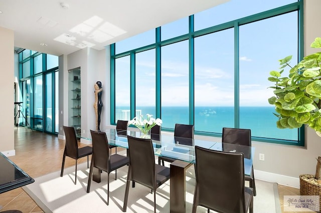 310A Padre Blvd Unit 3102, South Padre Island, TX 78597 - dining area with plenty of natural light, tile patterned flooring, a water view, baseboards, and floor to ceiling windows