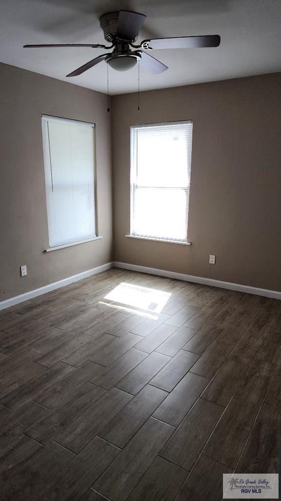 unfurnished room featuring ceiling fan and dark wood-type flooring