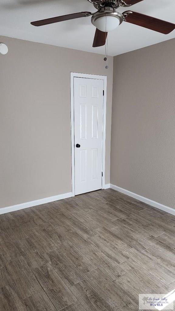 spare room with ceiling fan and dark hardwood / wood-style floors